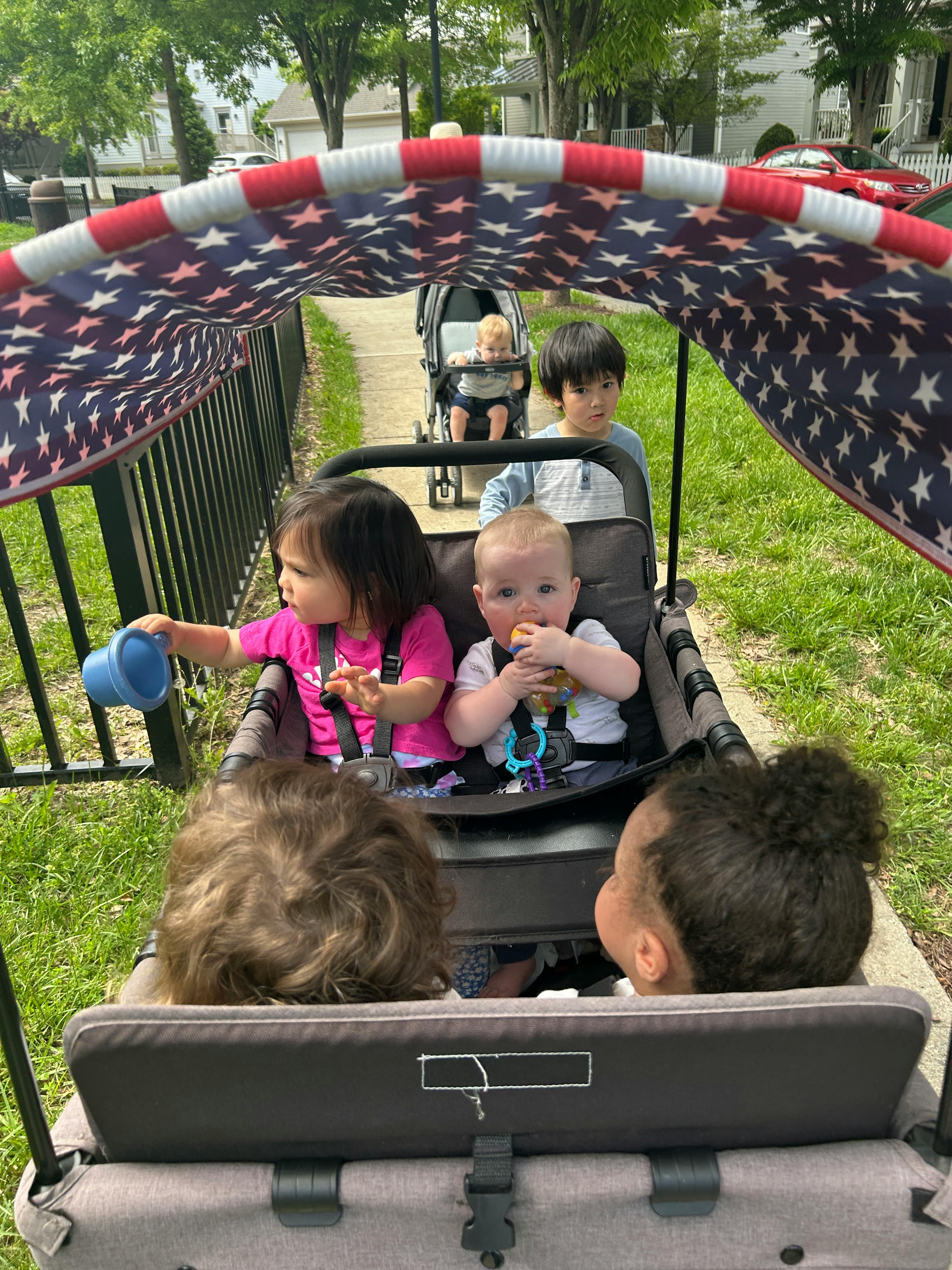 Children riding in a wagon with a patterned canopy
