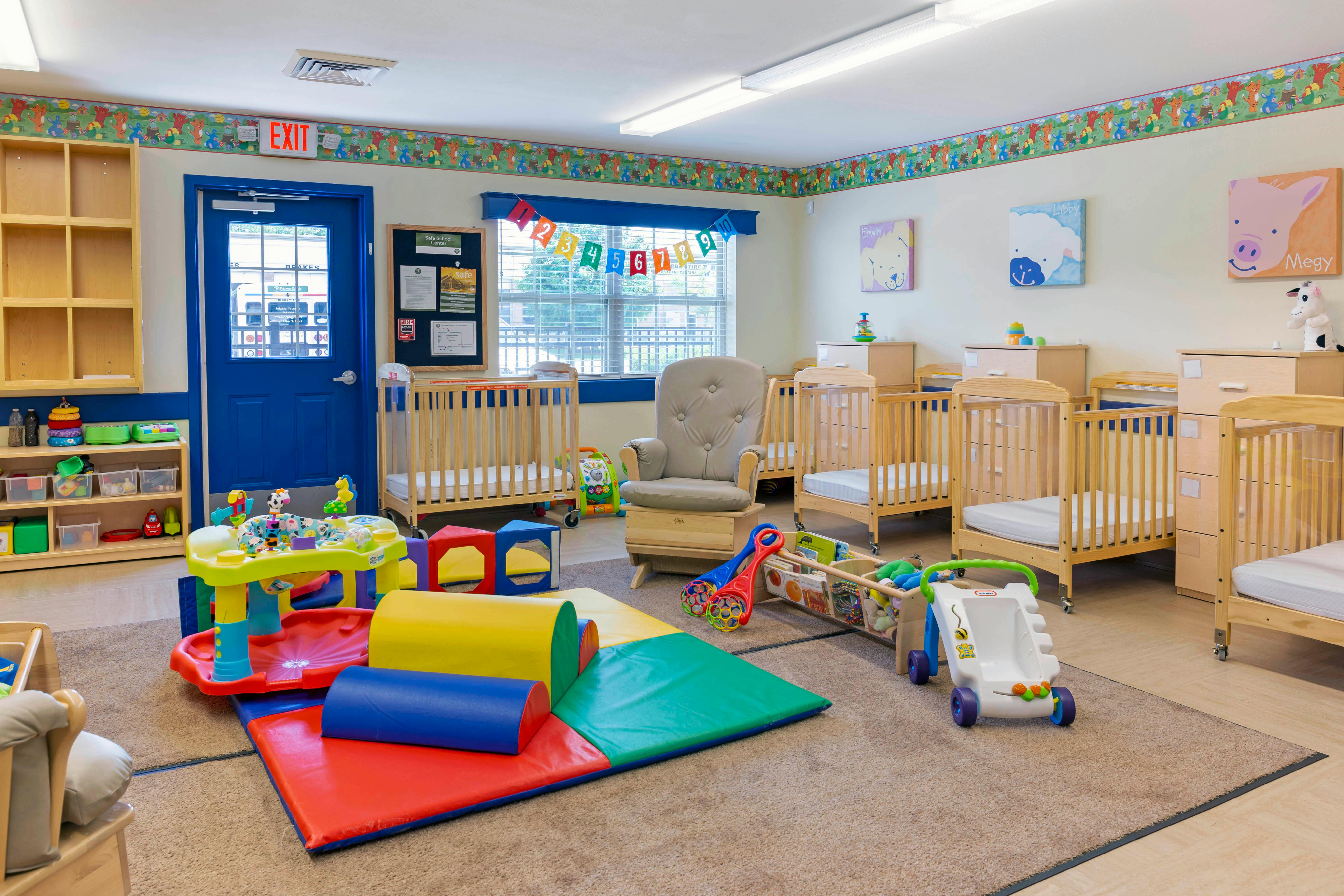 Baby room with cribs, play mats, toys, and a rocking chair