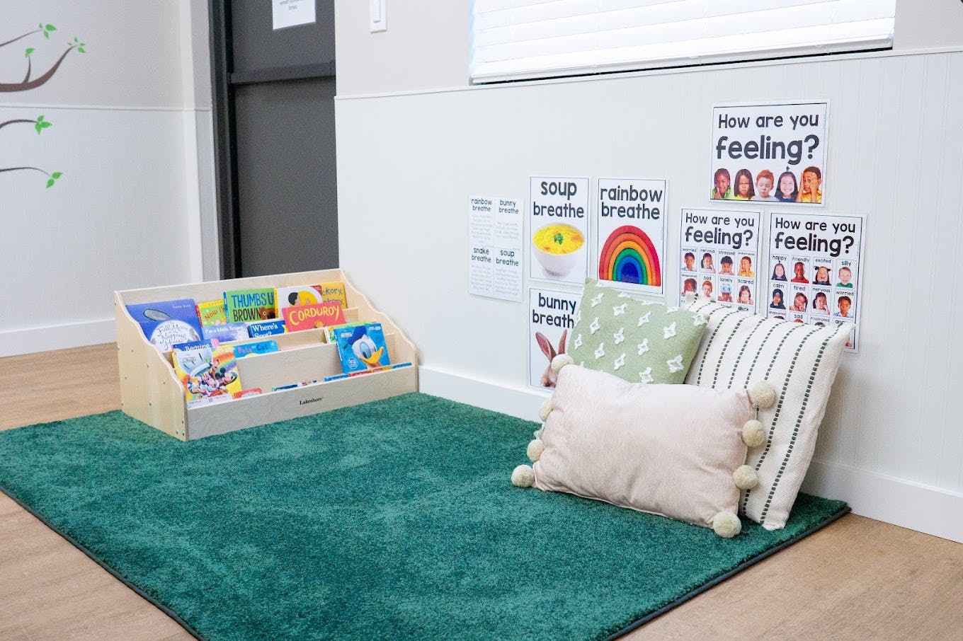 Reading corner with a book display, floor pillows, and emotion posters