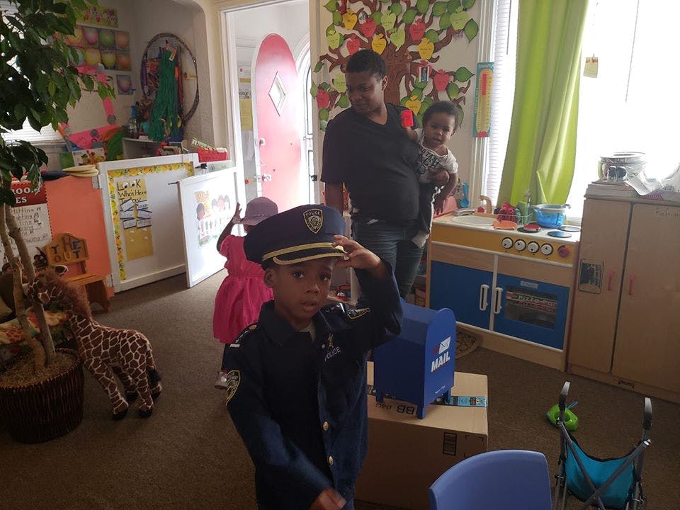 Child in police uniform saluting in a classroom