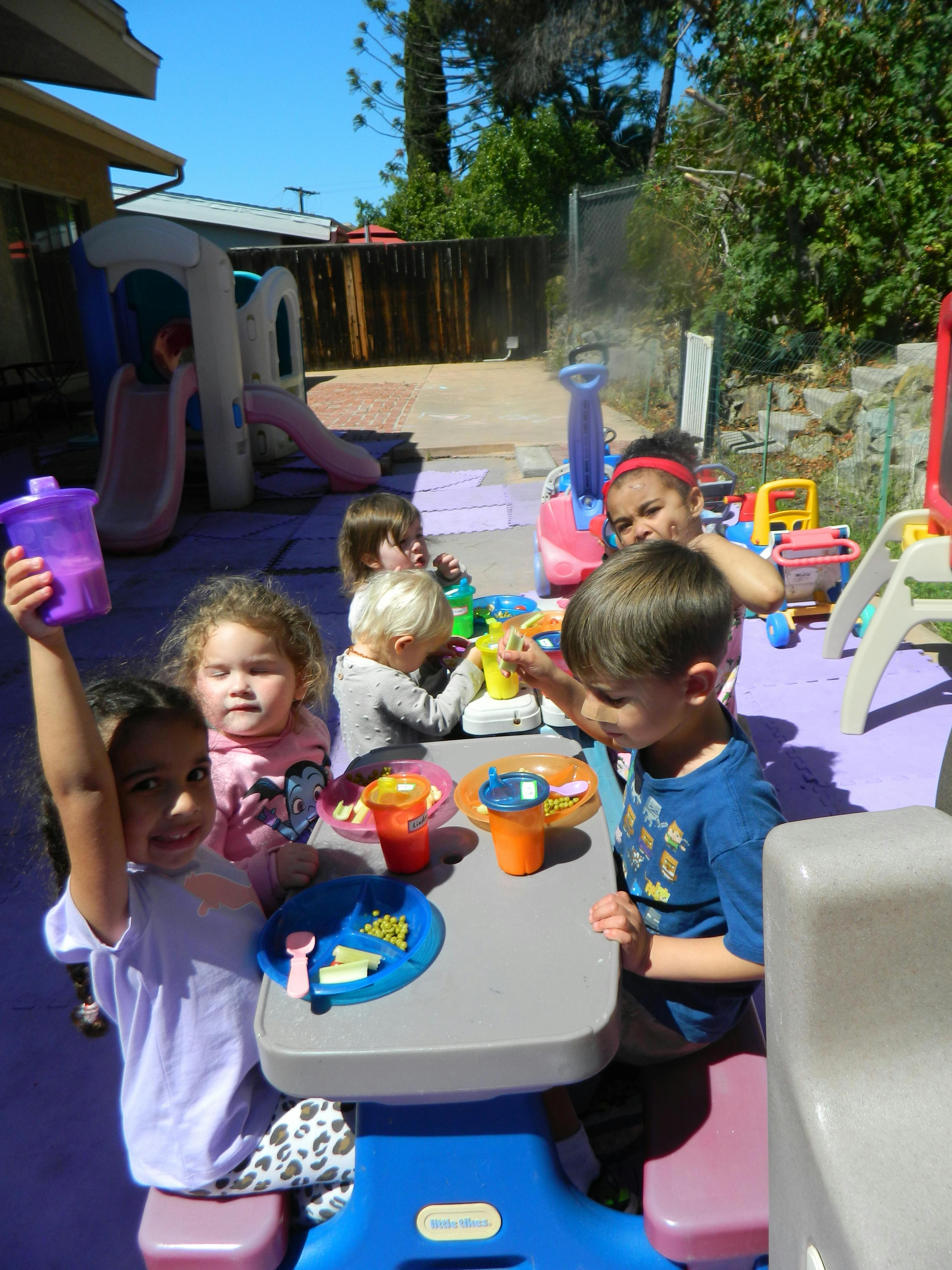 Children playing at a small table outdoors