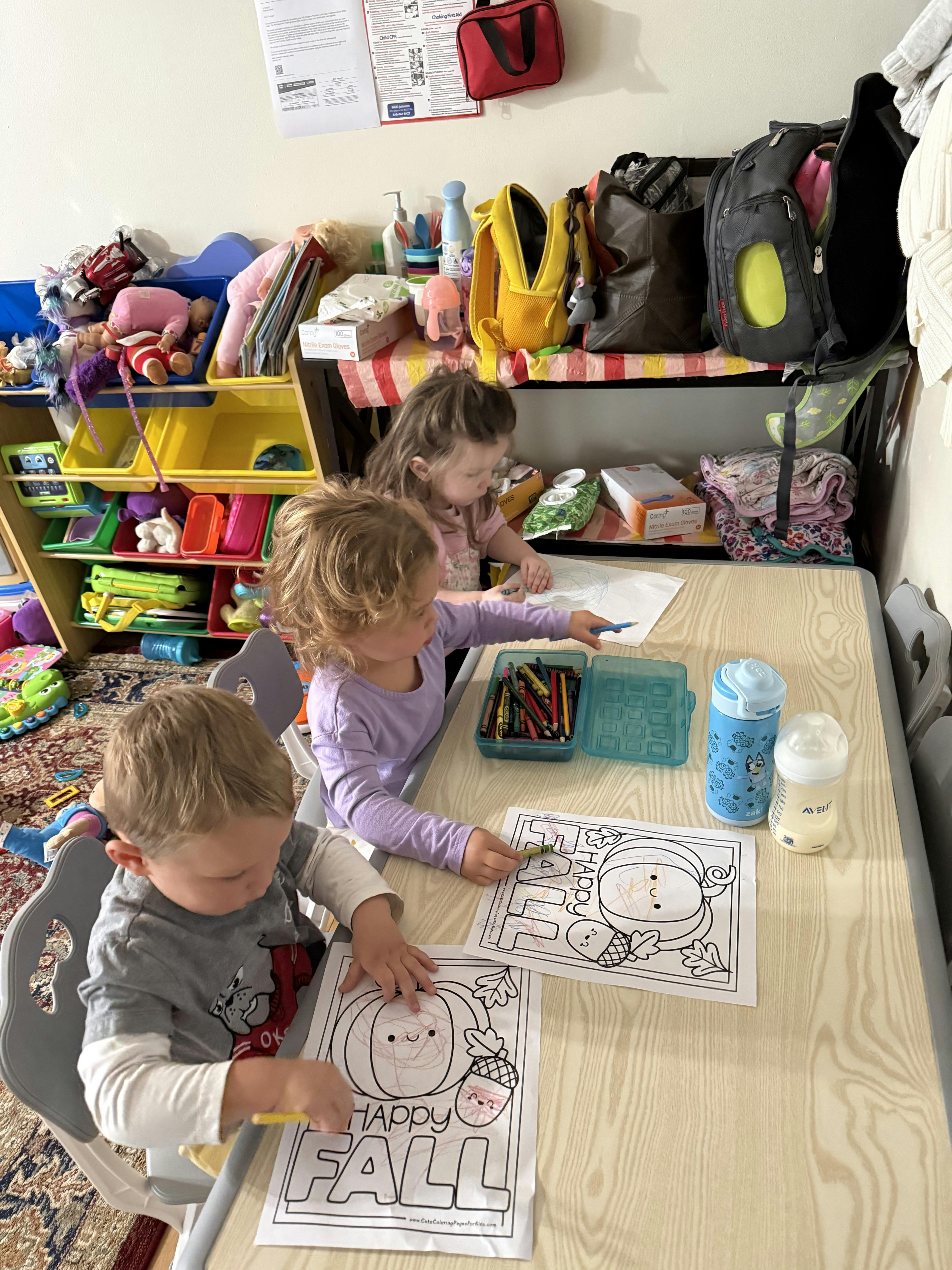 Three children coloring at a table