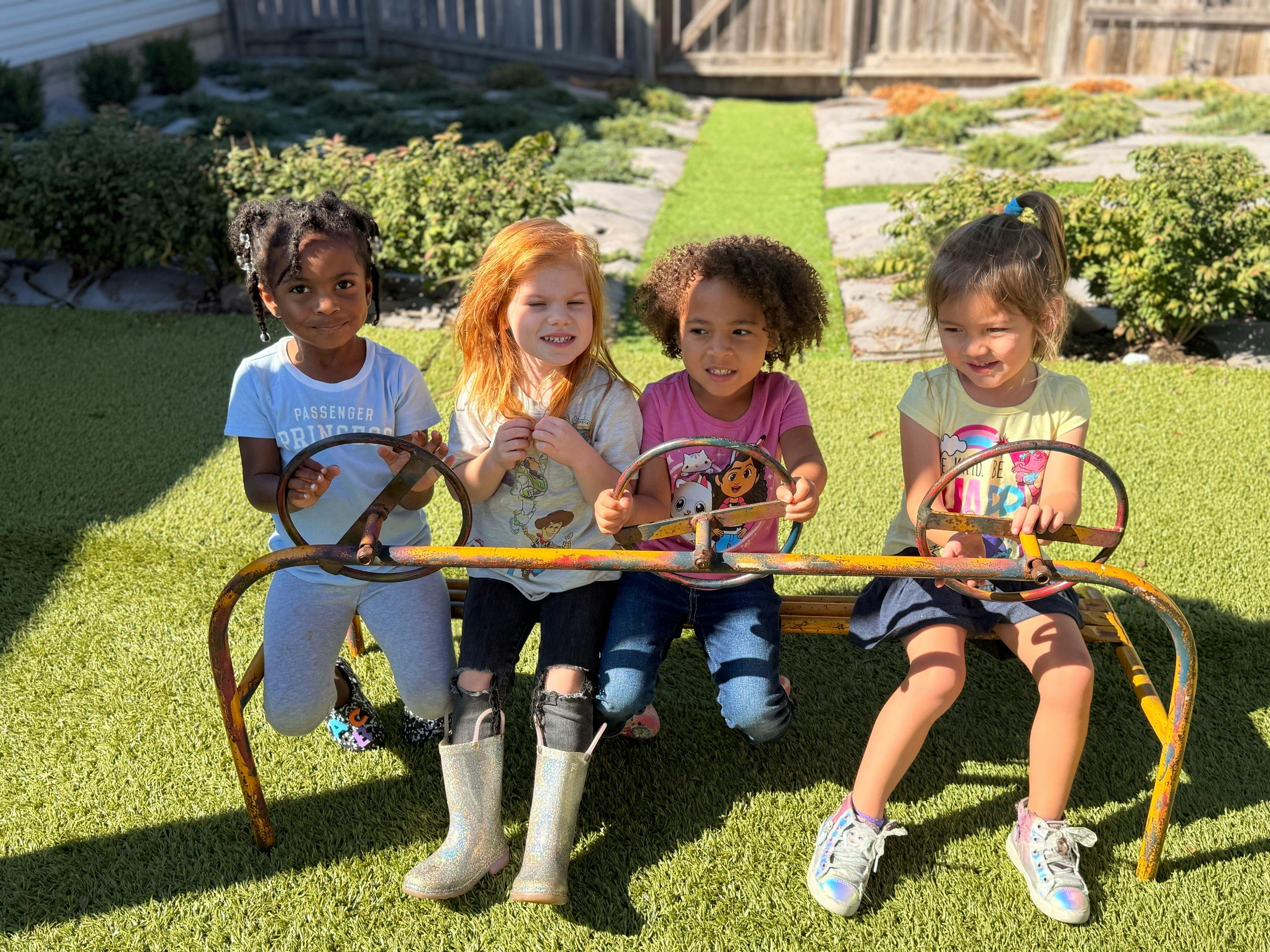 Four children sitting on a metal play structure
