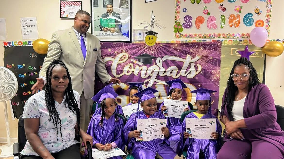 Adults and children in graduation caps and gowns holding certificates