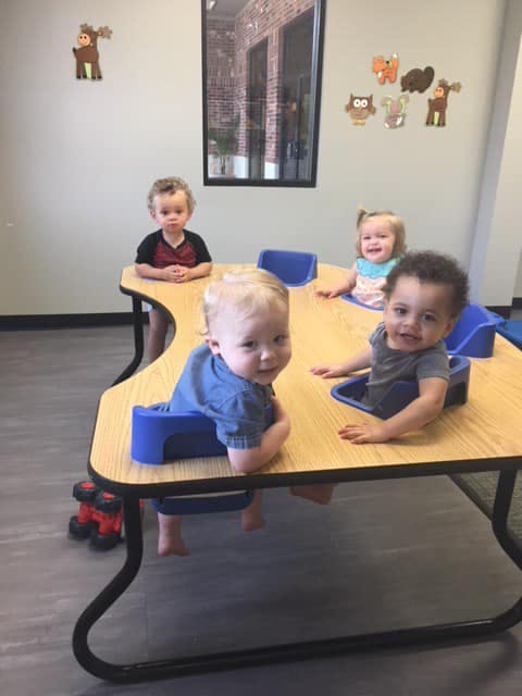 Four children sitting at a table with built-in seats