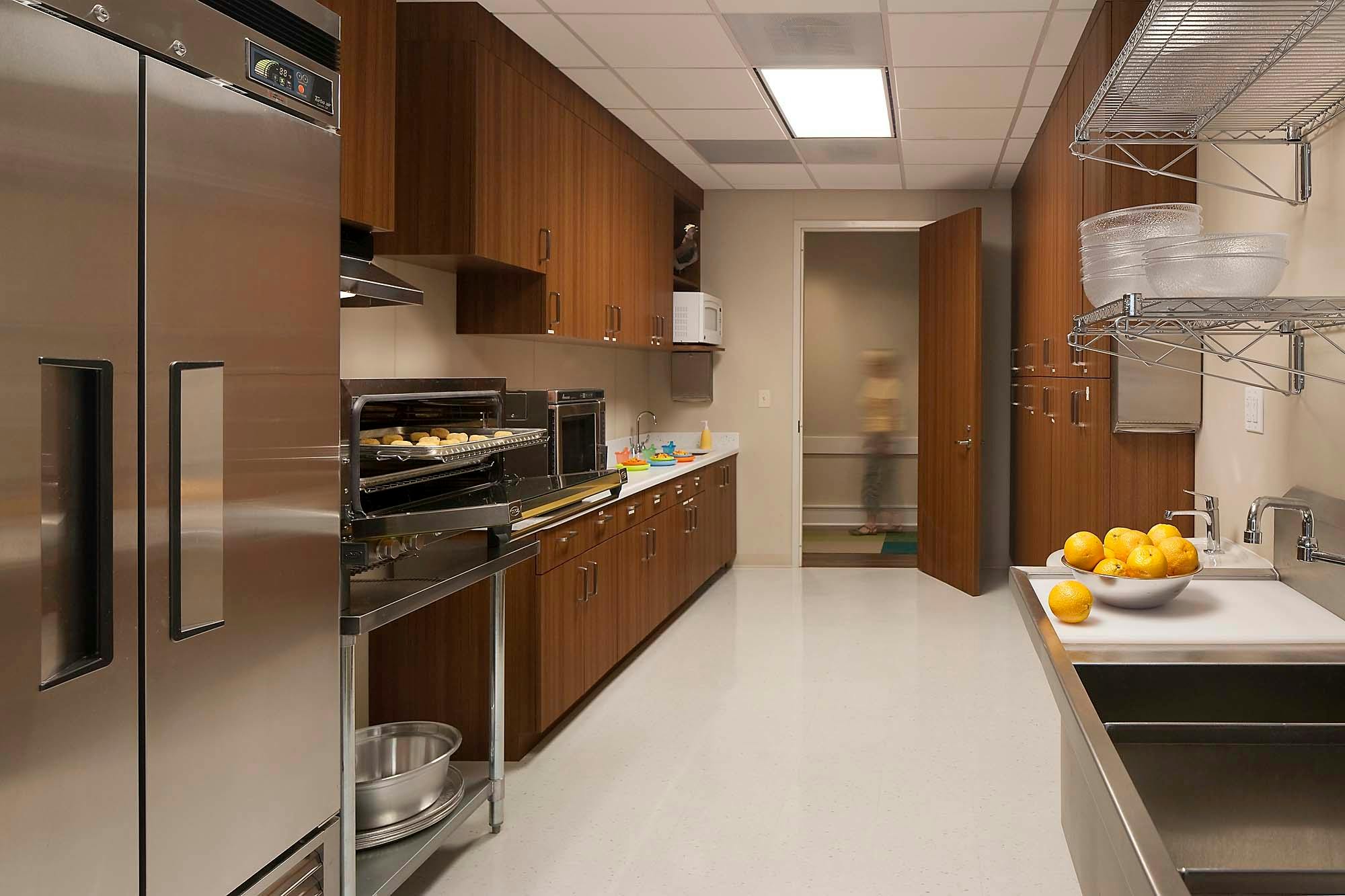 Commercial kitchen with stainless steel appliances and wooden cabinets