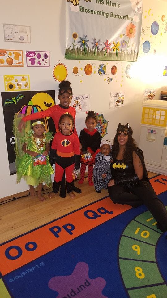Adult and children in costumes posing in a classroom