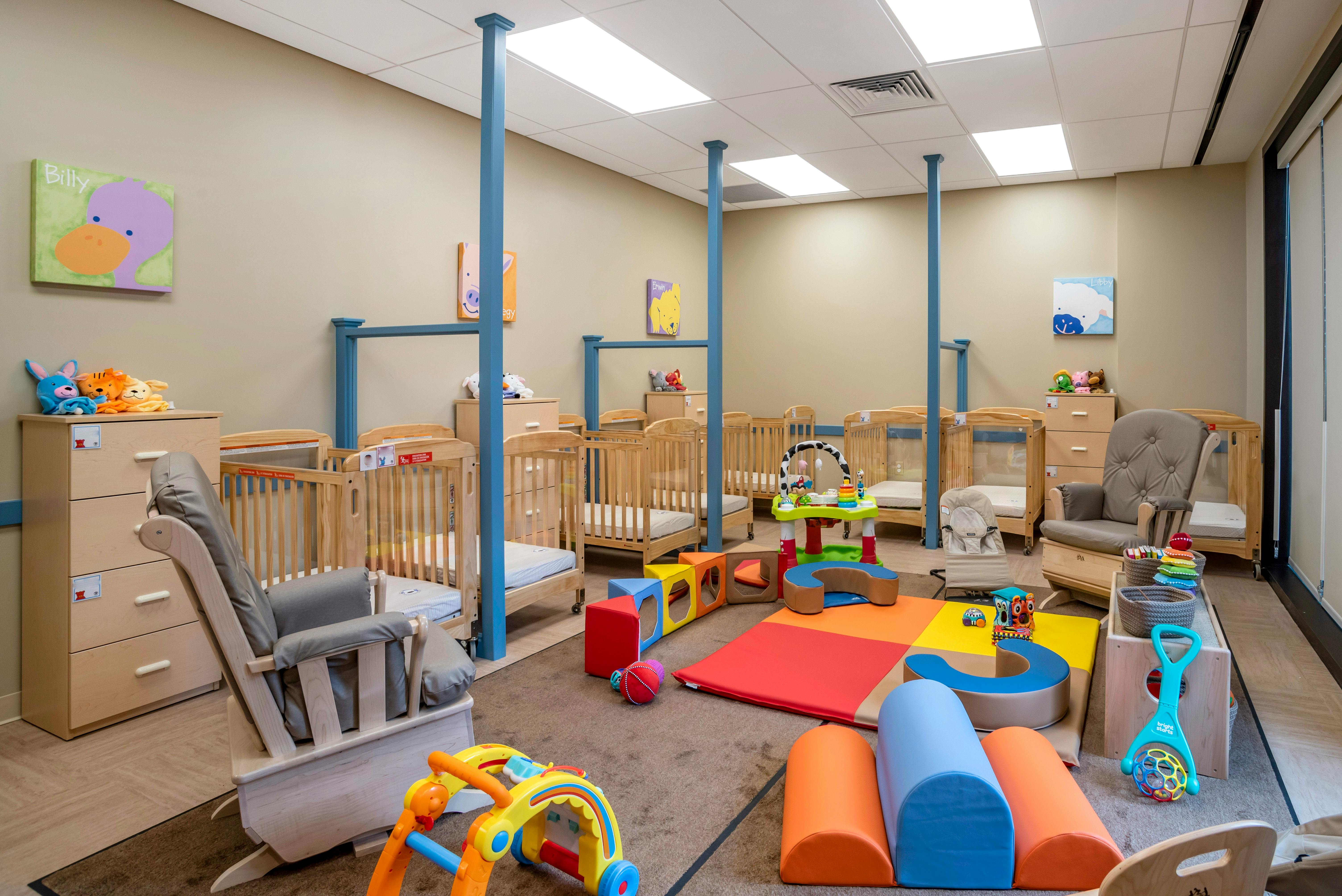 Cribs and play area in a brightly lit room