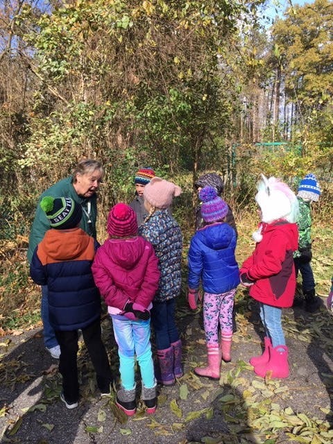 Adult speaking to a group of children outdoors