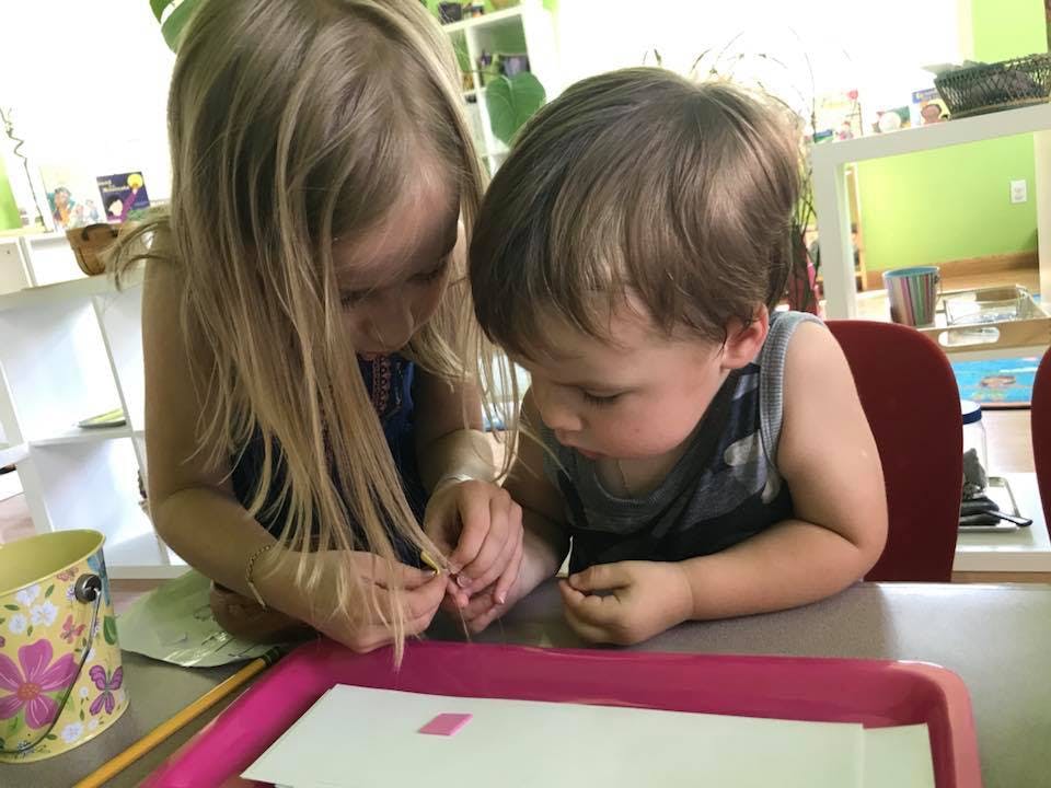 Two children looking at something on a table