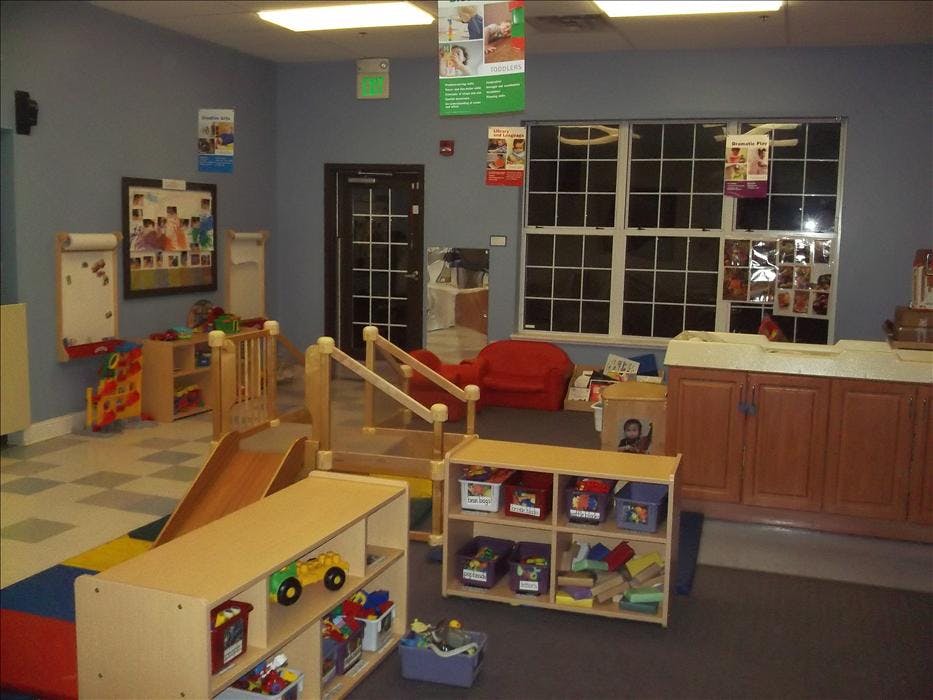 Classroom with play furniture, storage shelves, and a small slide