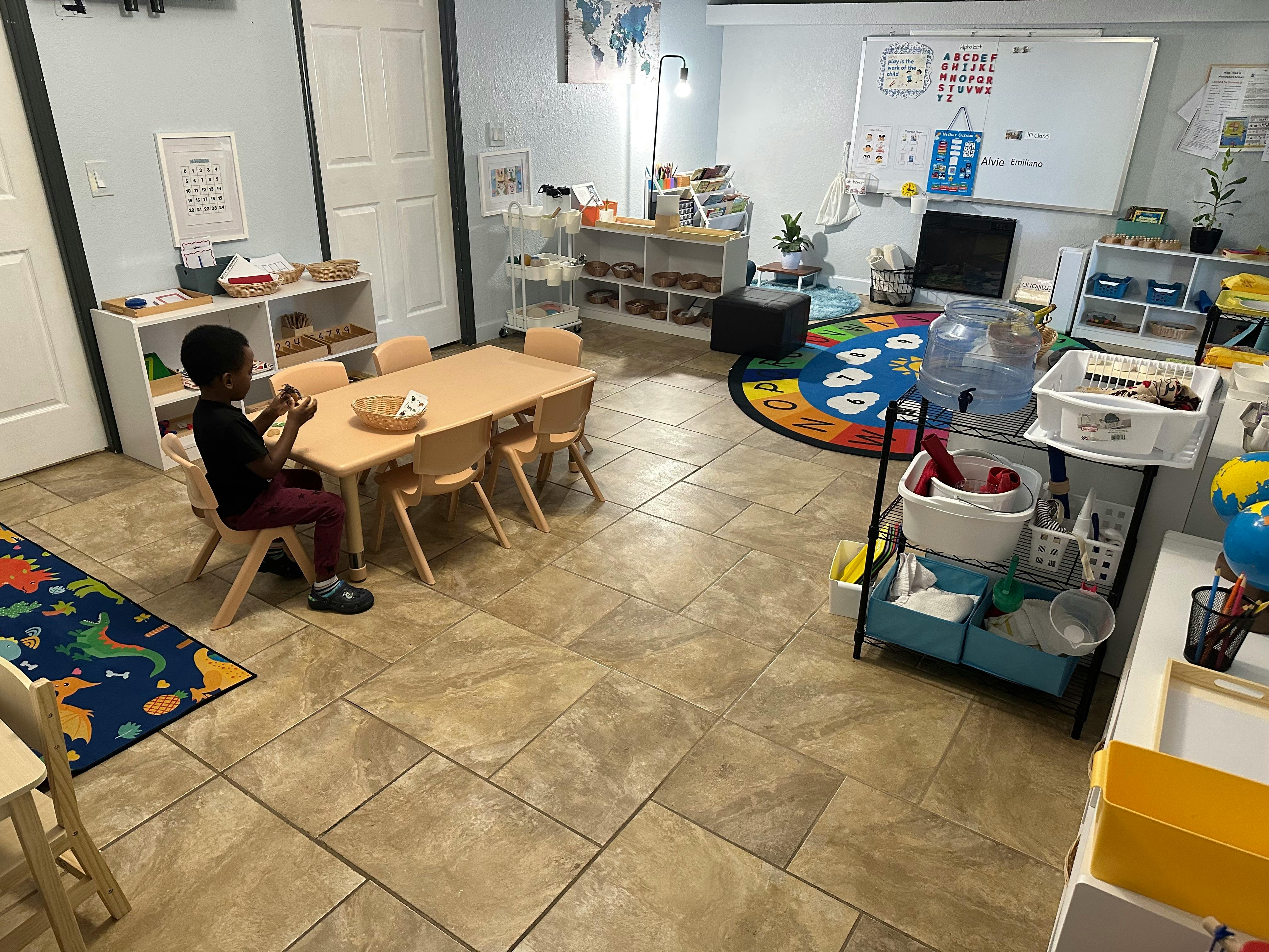 Child sitting at a small table in a classroom