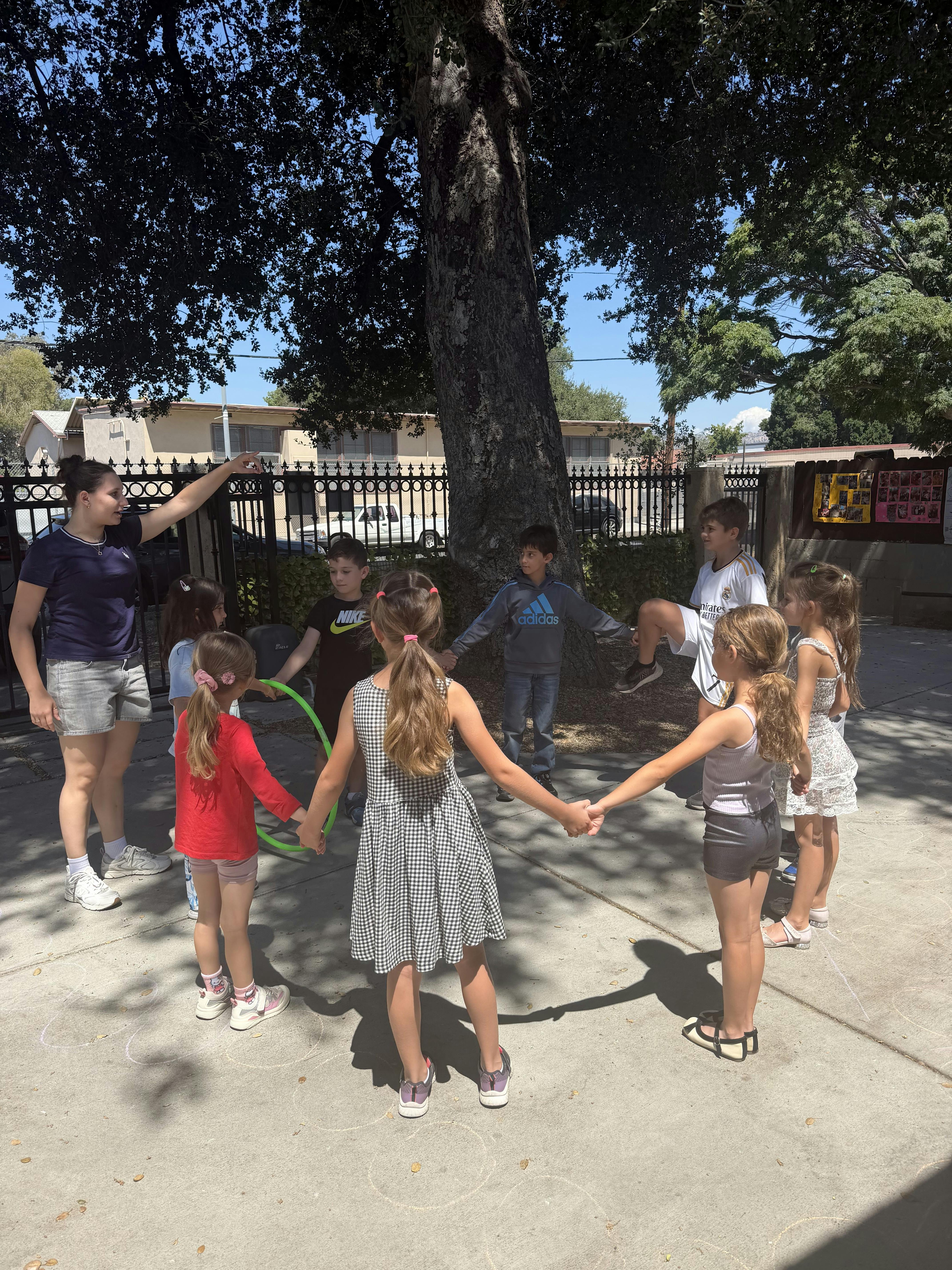 Group of children standing in a circle holding hands outdoors