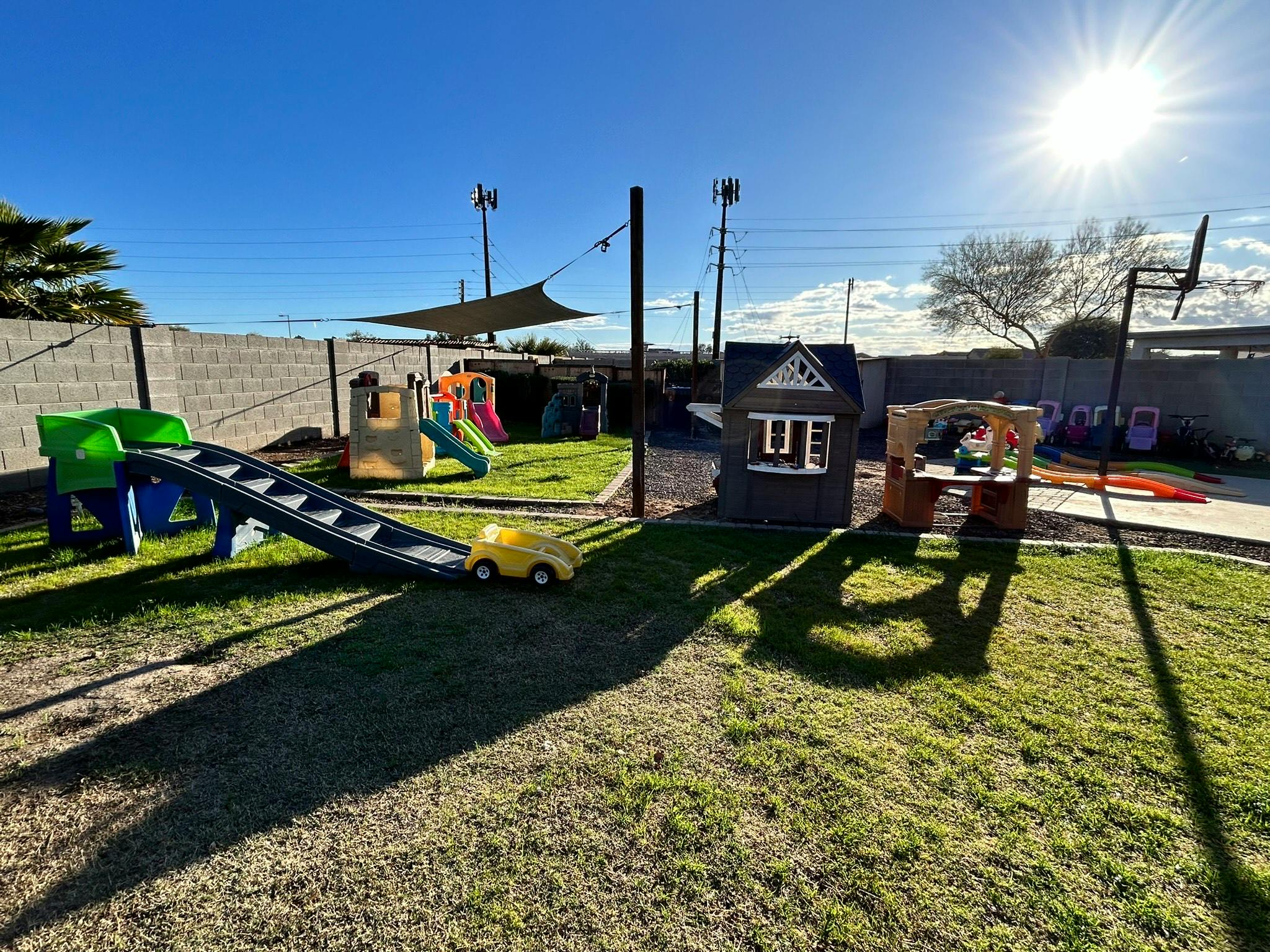 Outdoor playground with slides, playhouses, and a yellow toy car