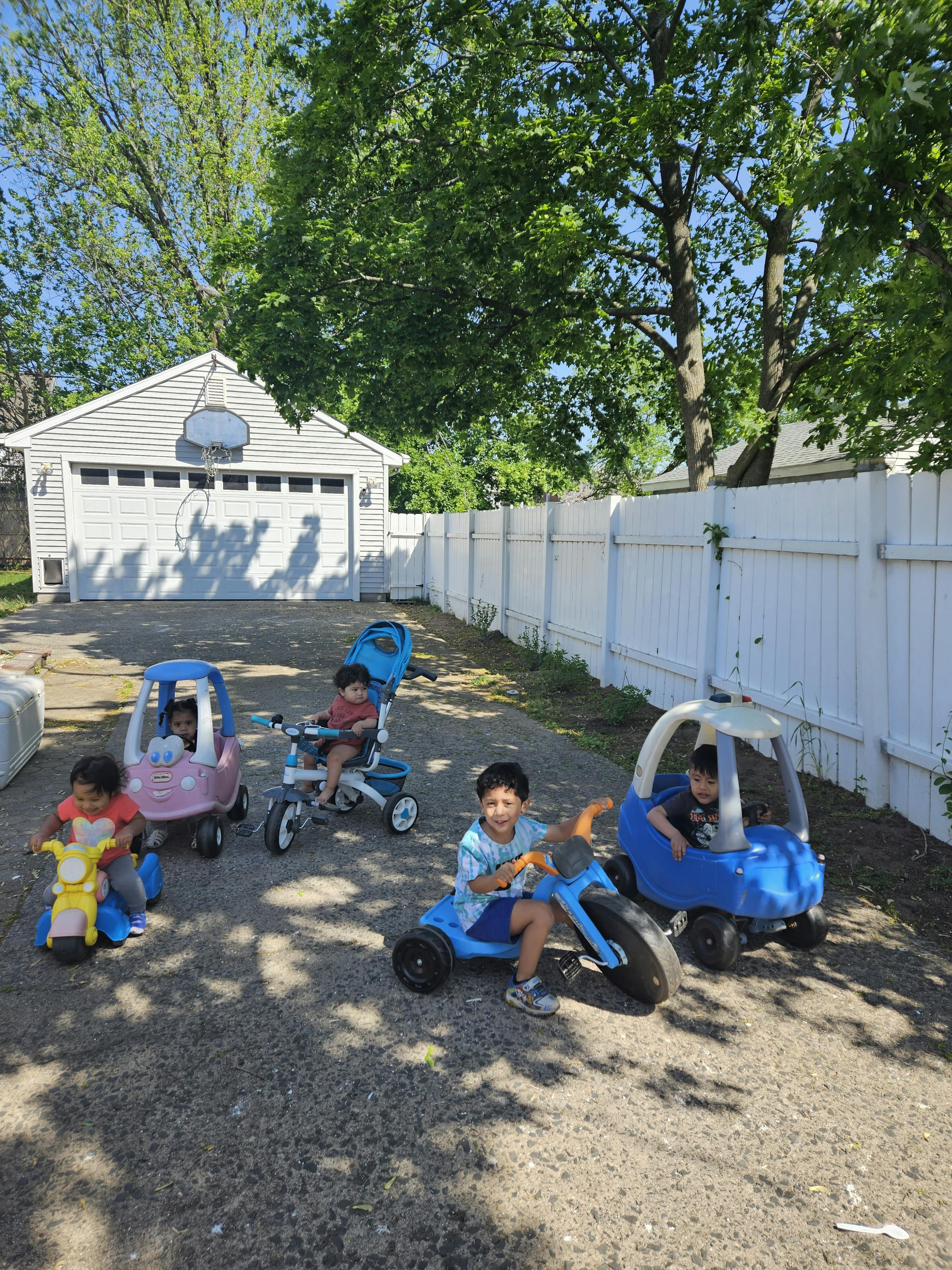 Children playing with ride-on toys outdoors