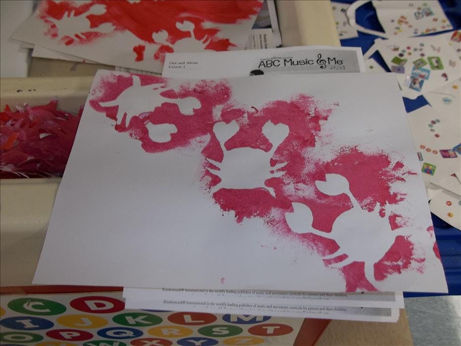 Pink spray paint art of crabs on white paper