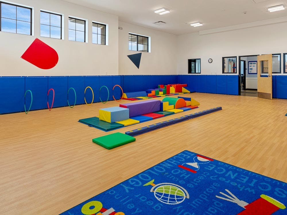 Indoor playroom with colorful soft play equipment and hula hoops