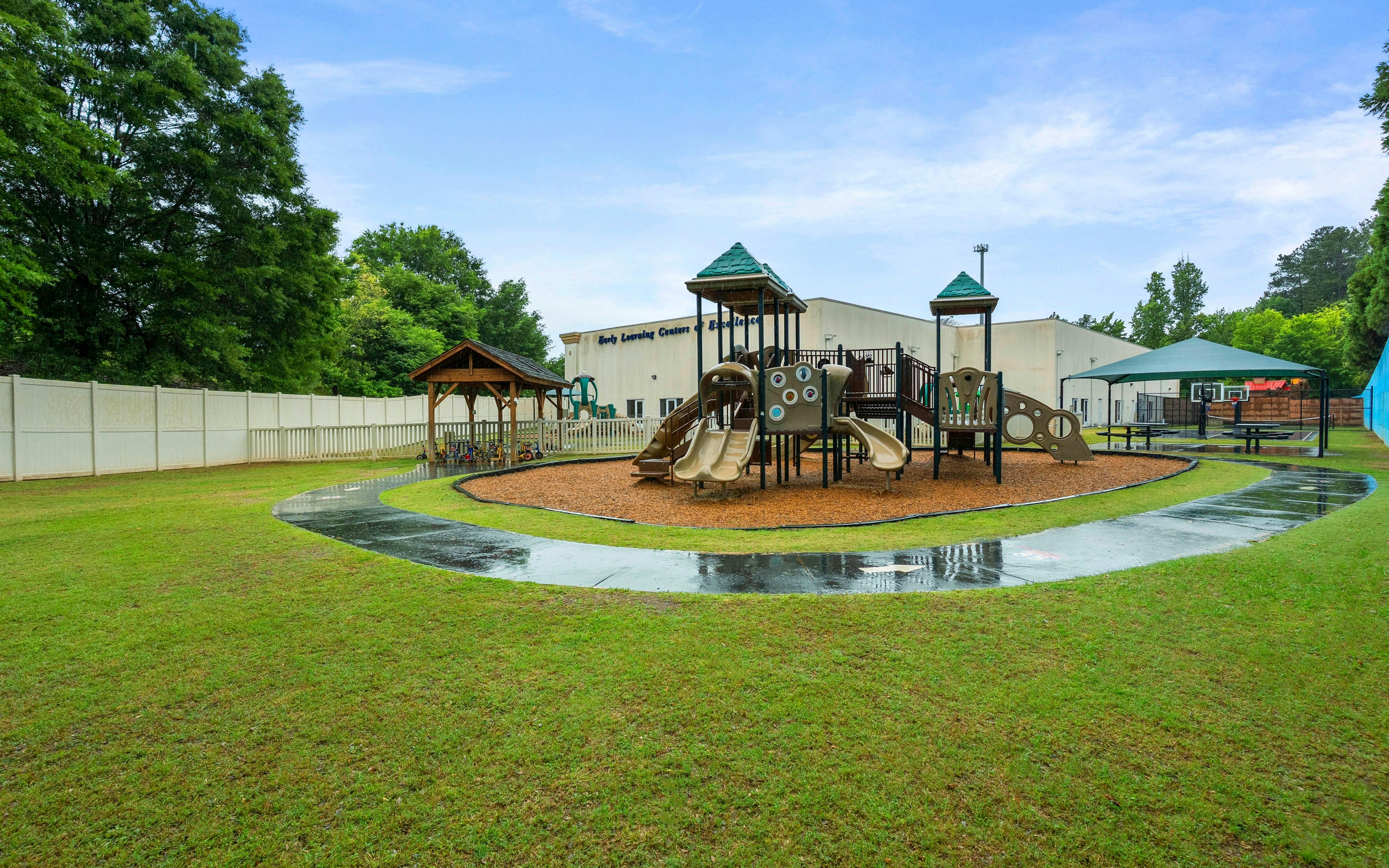 A children's playground with slides and climbing structures next to a building