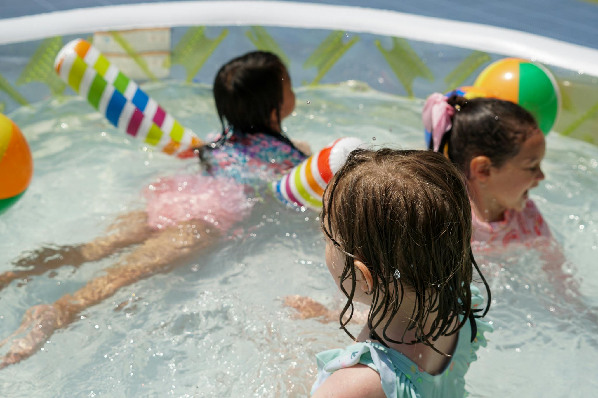 Children playing in a pool with inflatable toys
