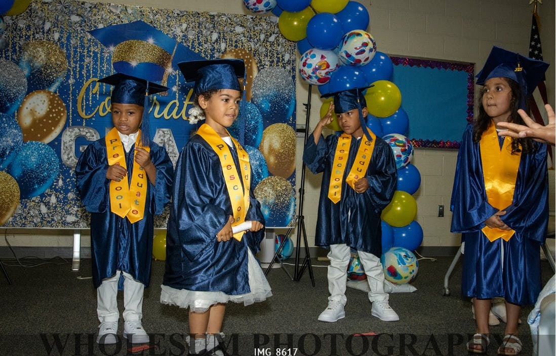Four children in graduation caps and gowns