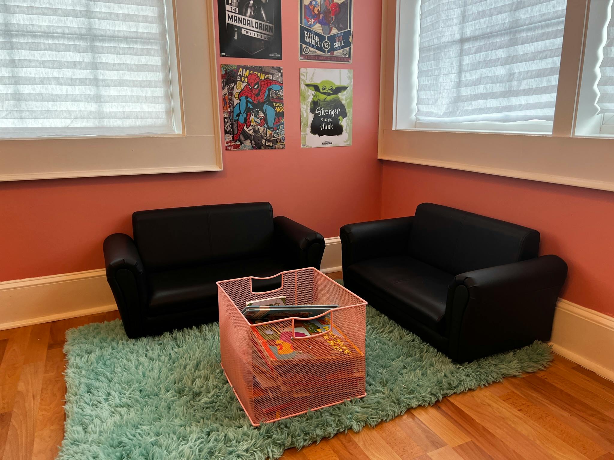 Two small black sofas facing each other with a storage cube between them