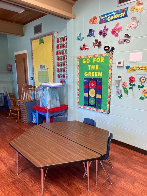 Classroom with tables, chairs, and colorful decorations on the walls