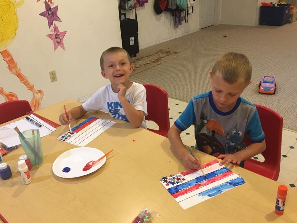 Two children painting at a table