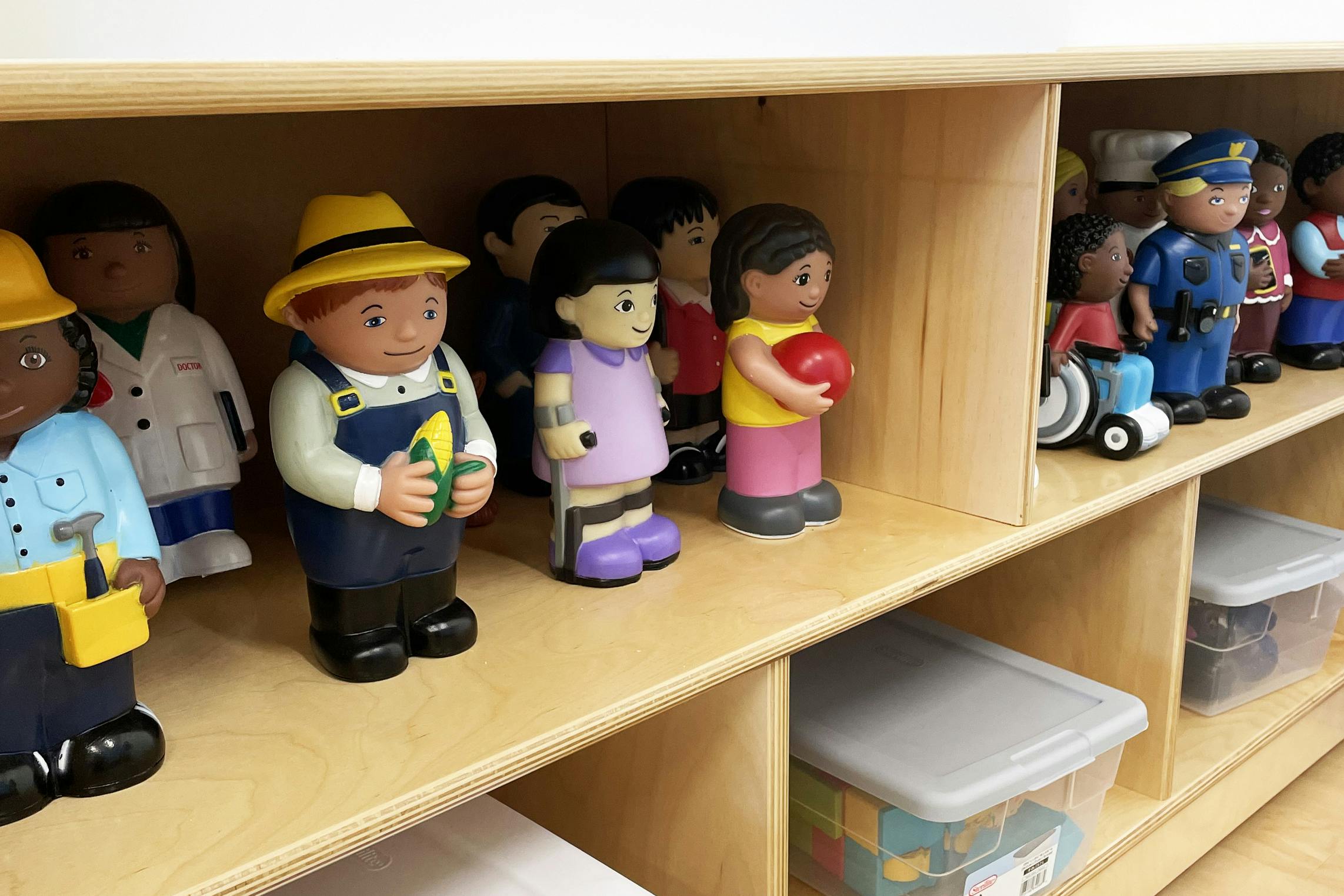 Children's figurines depicting various professions and a child in a wheelchair