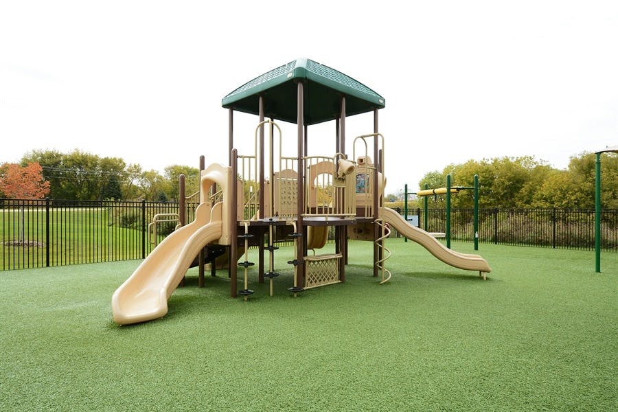 Playground with slides and climbing structures on green turf