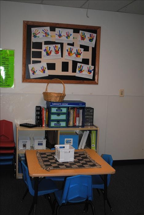 Classroom corner with a bulletin board displaying colorful handprints