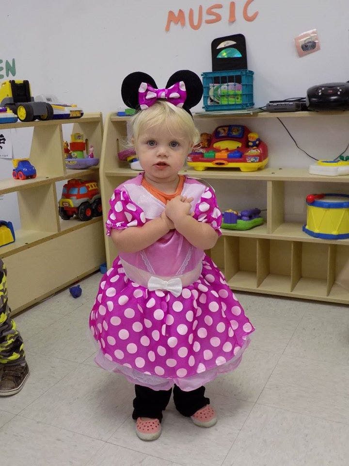 Child in a pink polka dot dress and mouse ears headband