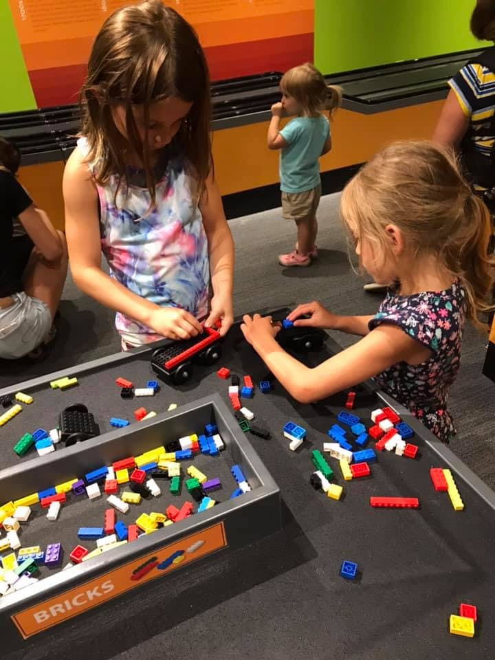 Two children playing with colorful building blocks on a table