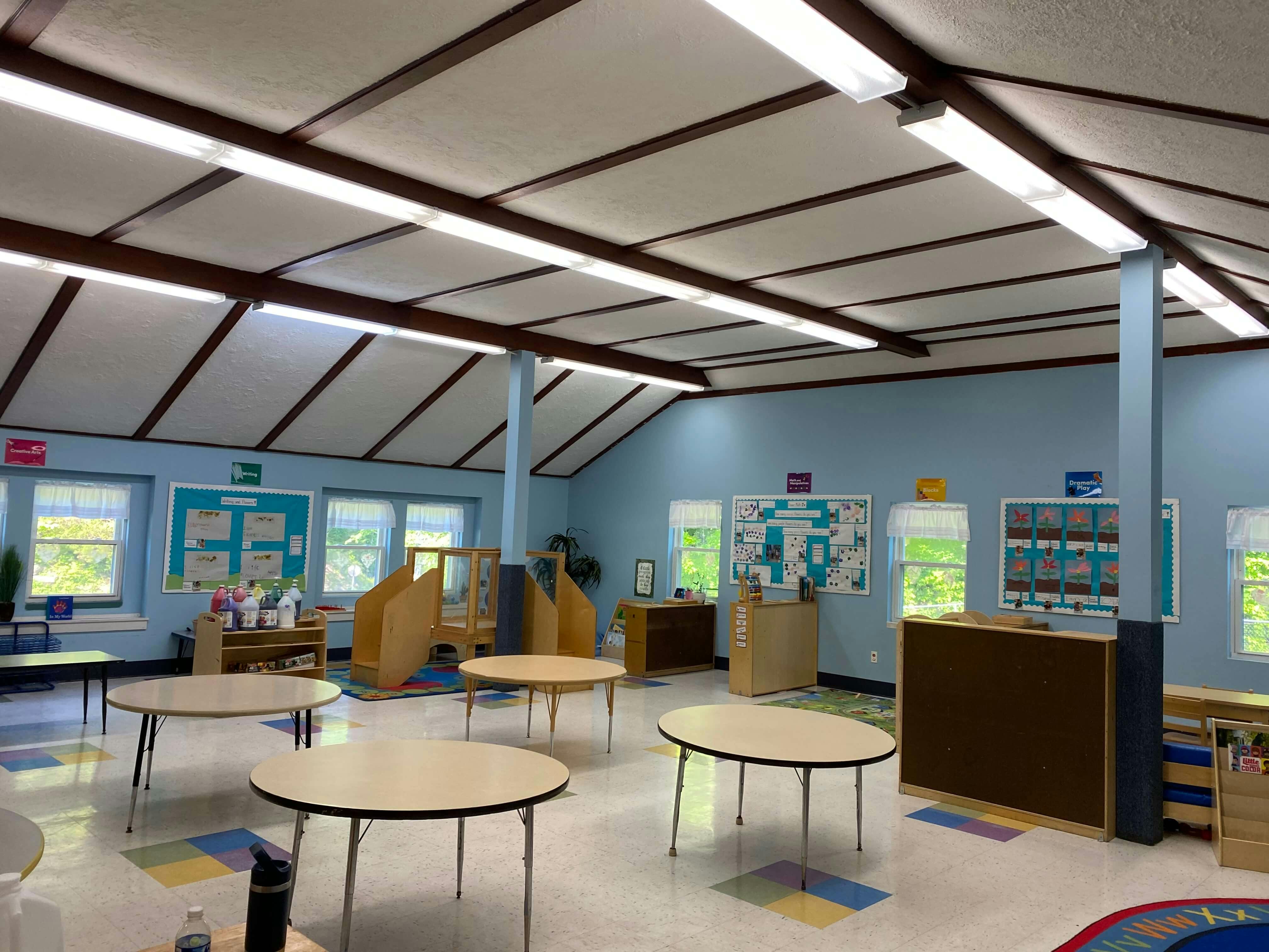 Empty classroom with small tables and various learning centers