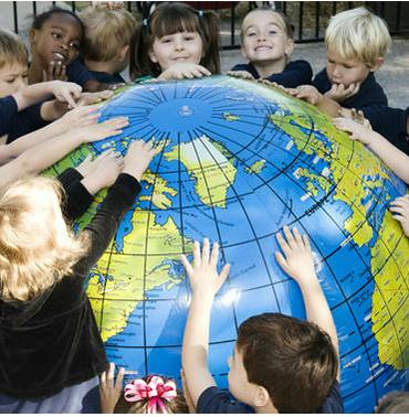 Children gathered around a large inflatable globe