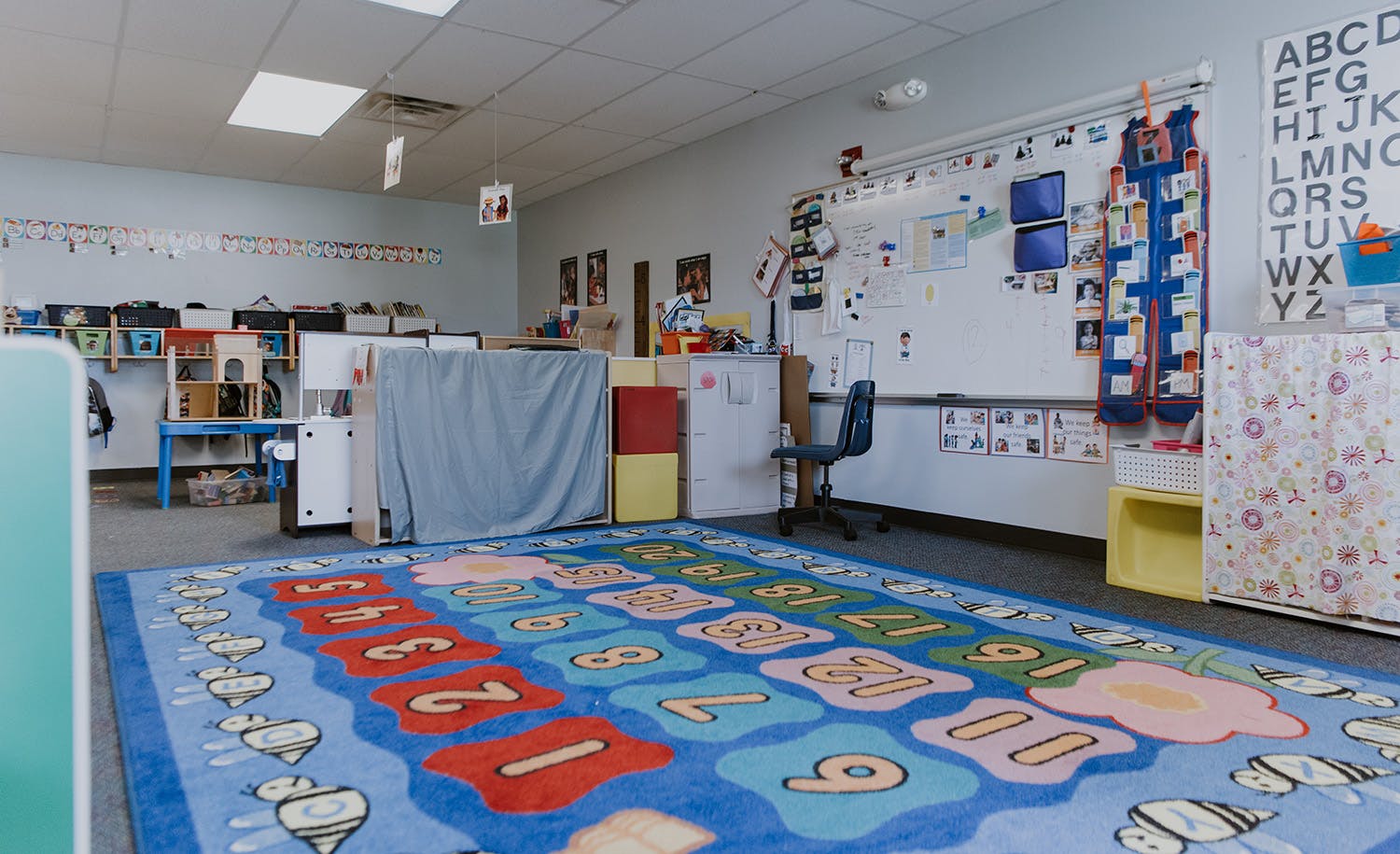 Classroom with a colorful number rug and whiteboards