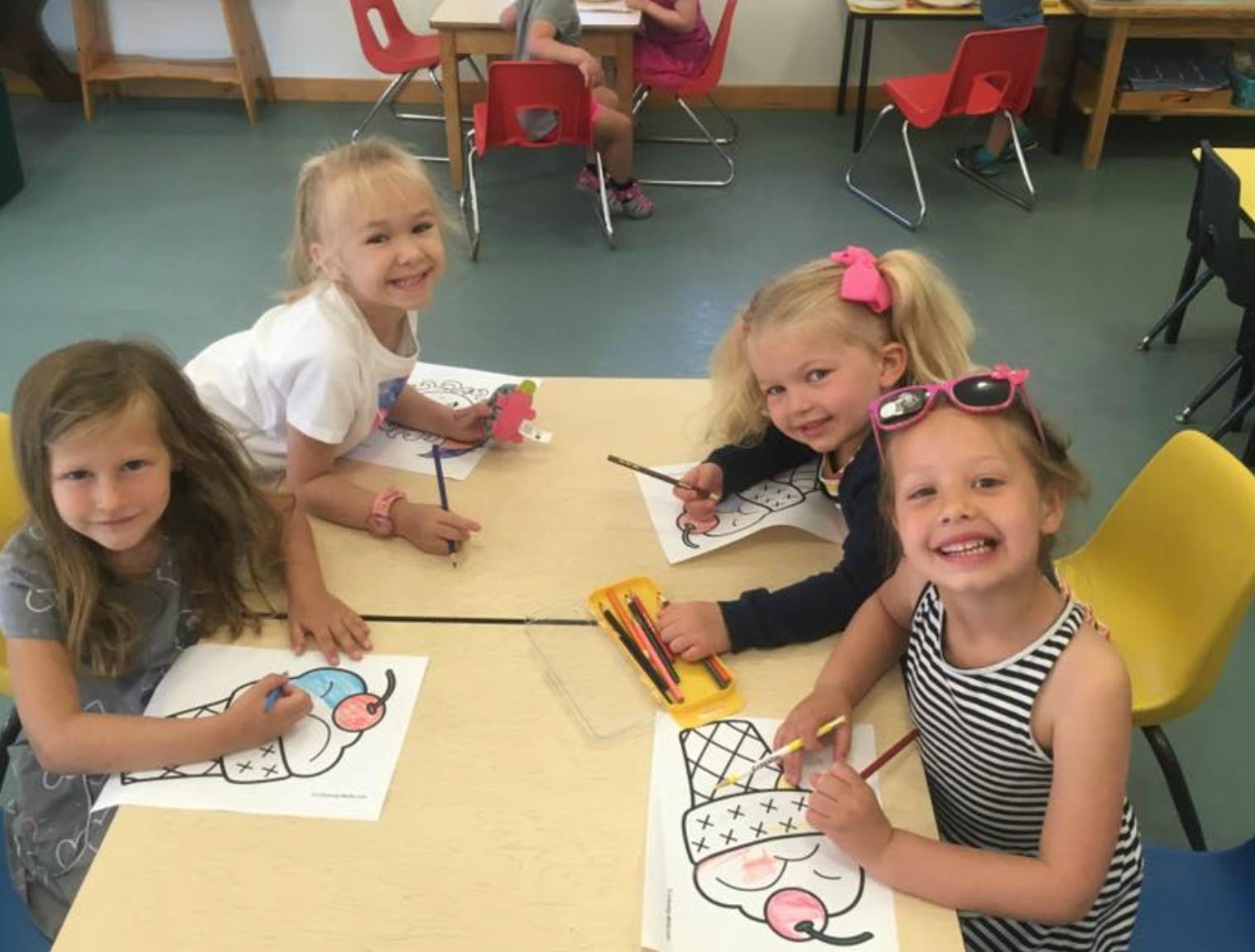 Four children coloring at a table