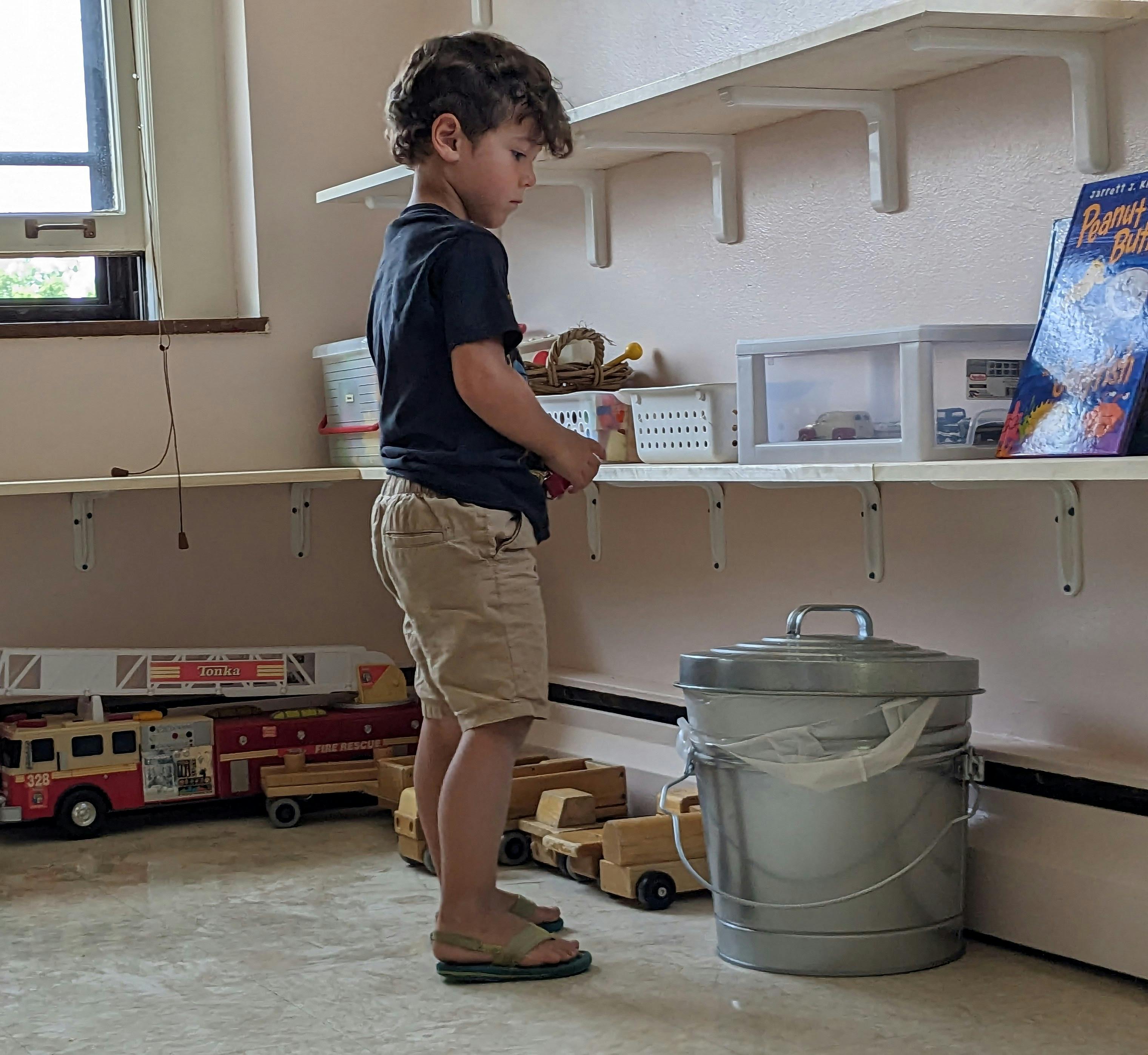 Child standing in front of shelves with toys