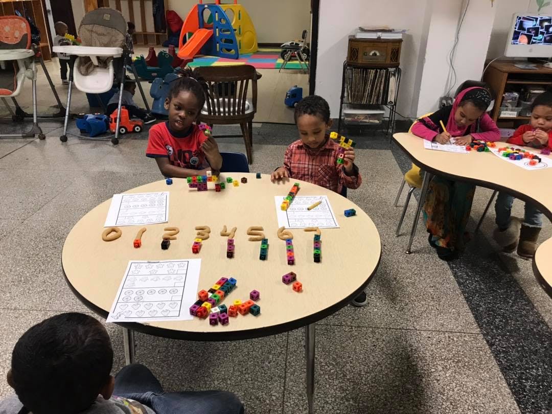 Children playing with blocks and numbers at a table