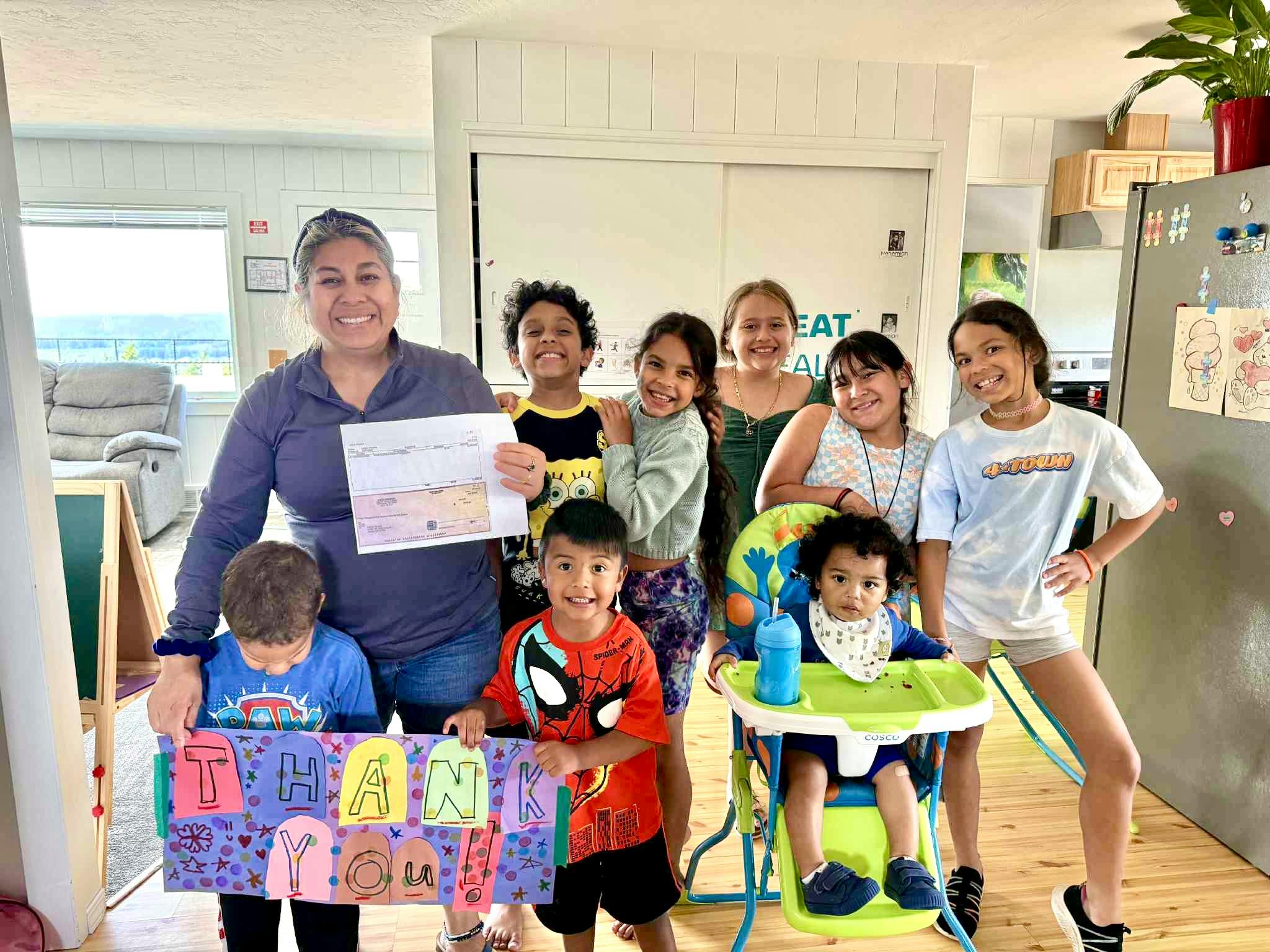 Person holding a certificate with a group of children and teens