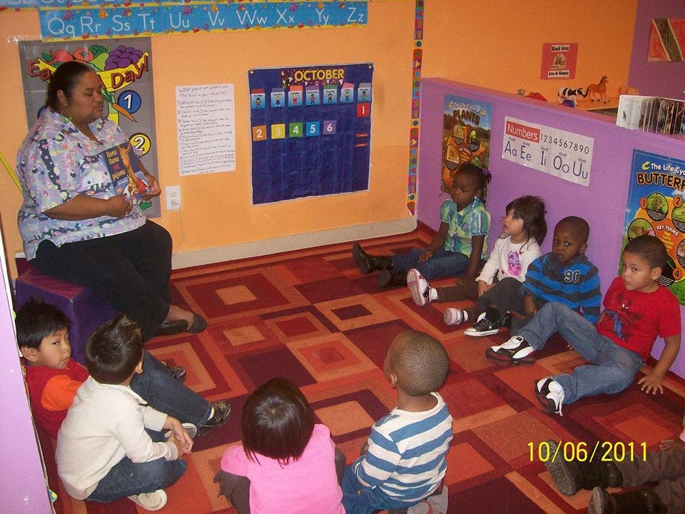 Adult reading to children in a classroom