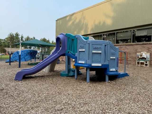 Playground with slides and climbing structures on wood chips