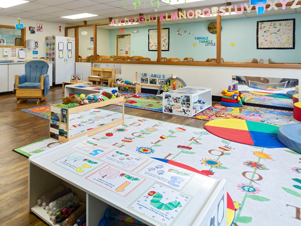 Colorful and organized play area with toys, rugs, and educational materials