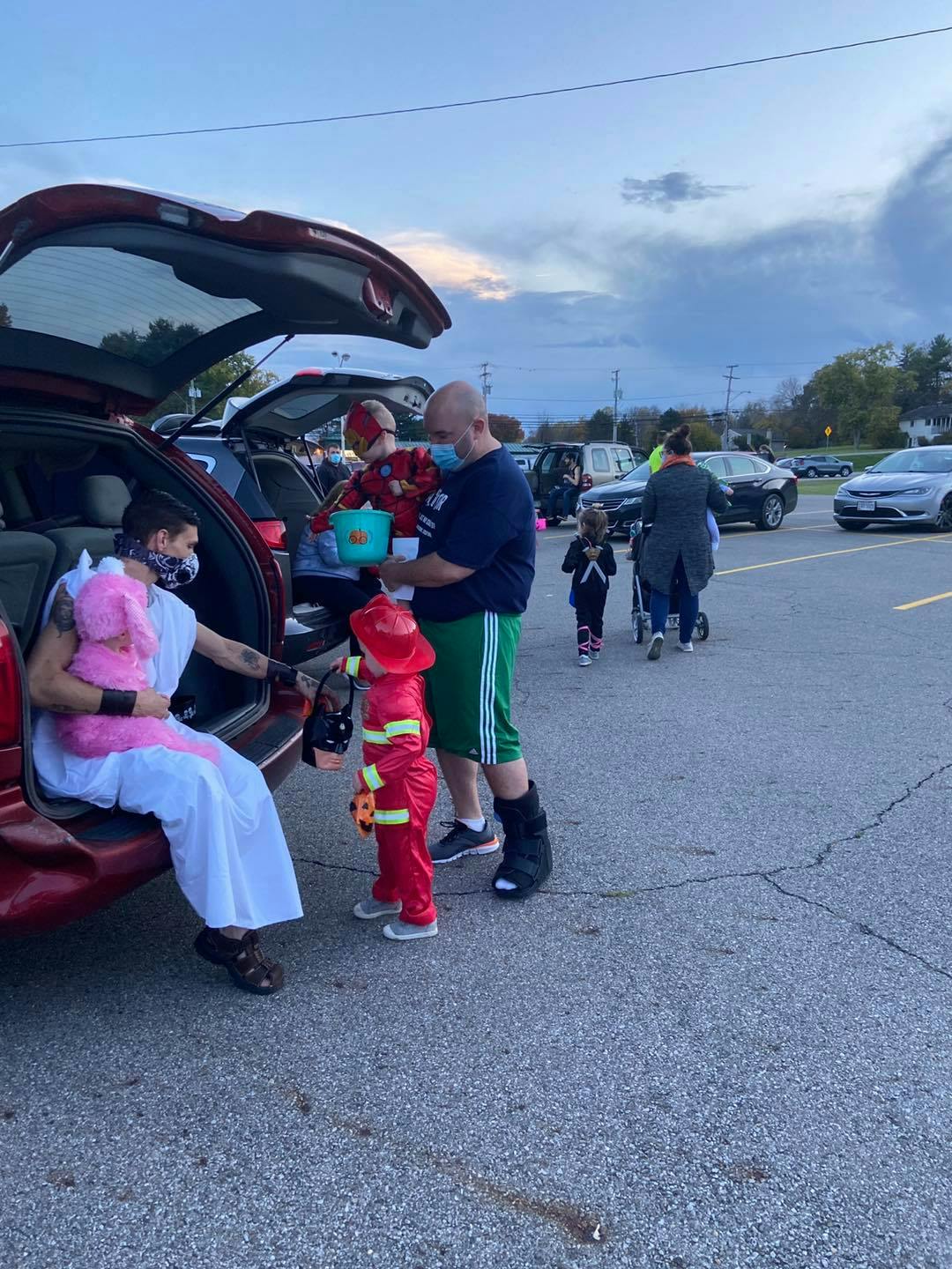 People and children in costumes at a trunk-or-treat event