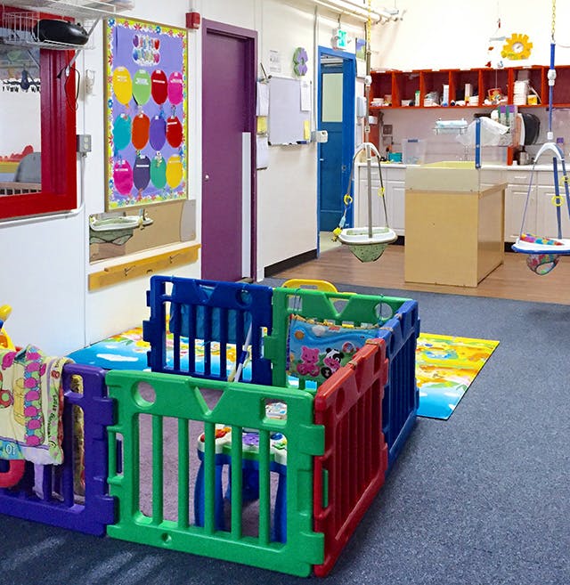 Colorful playpen in a room with a purple door and a blue door