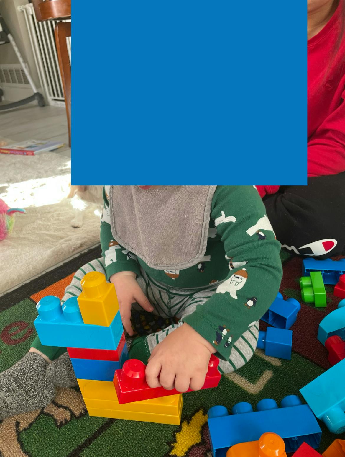 Child playing with colorful building blocks on a rug