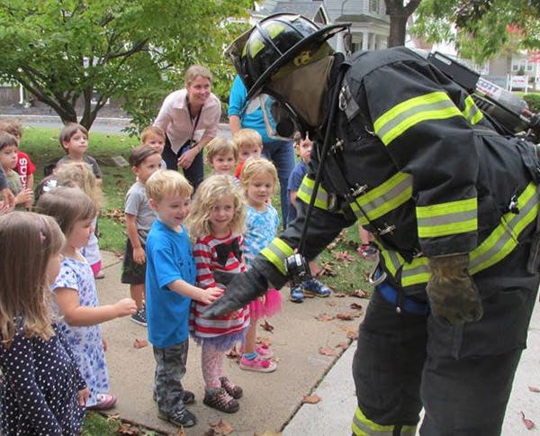 Firefighter in uniform interacting with children