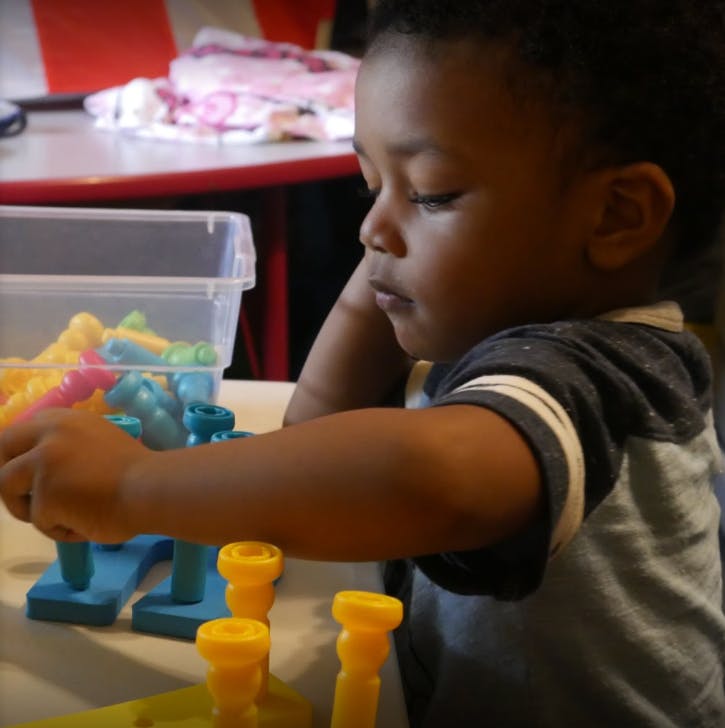 Child playing with colorful peg toys