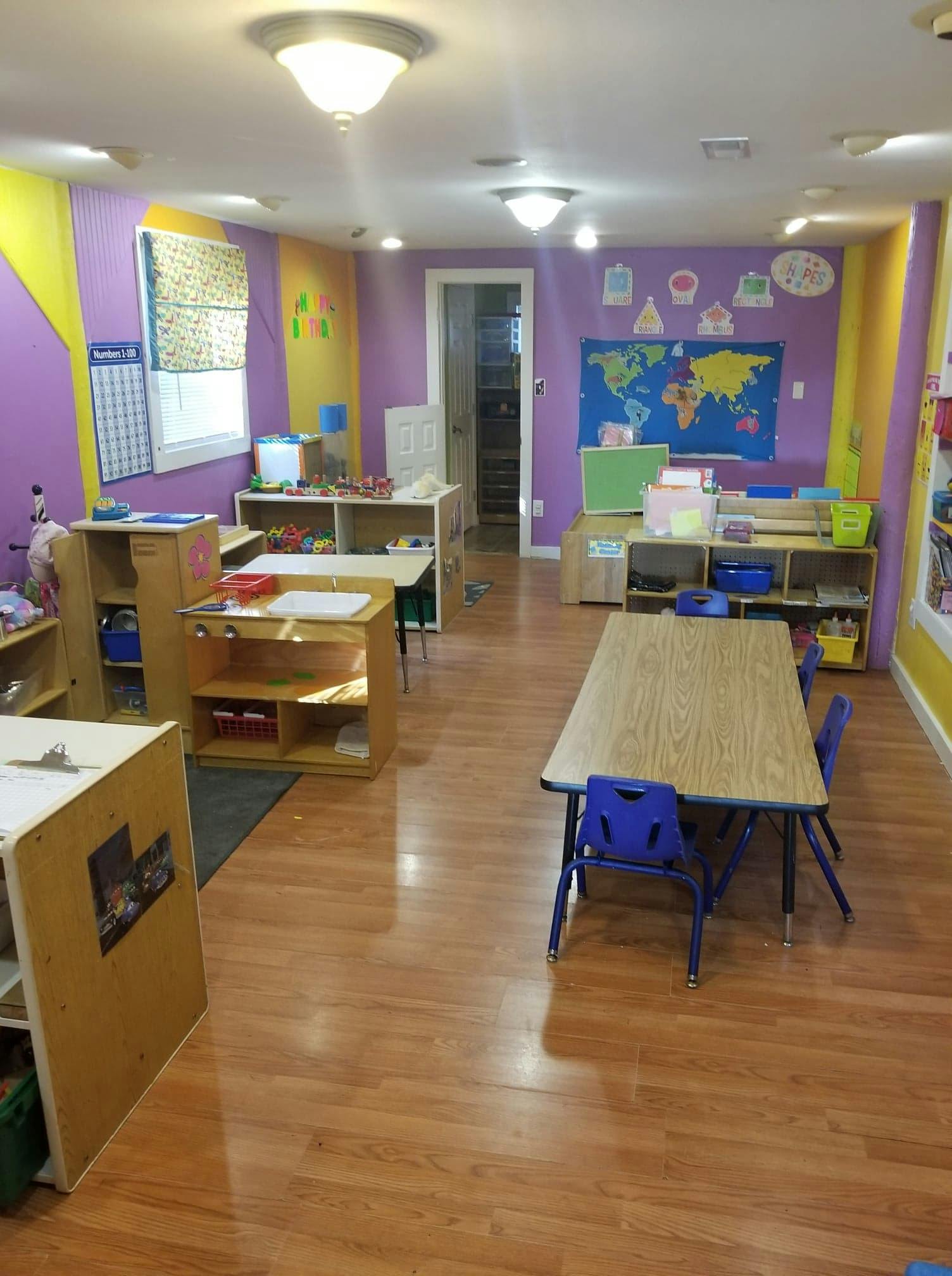 Classroom with tables, chairs, and shelves with learning materials