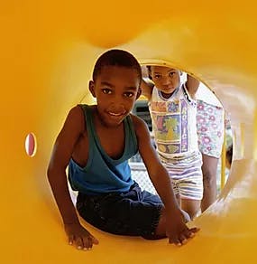 Two children in a yellow play tunnel