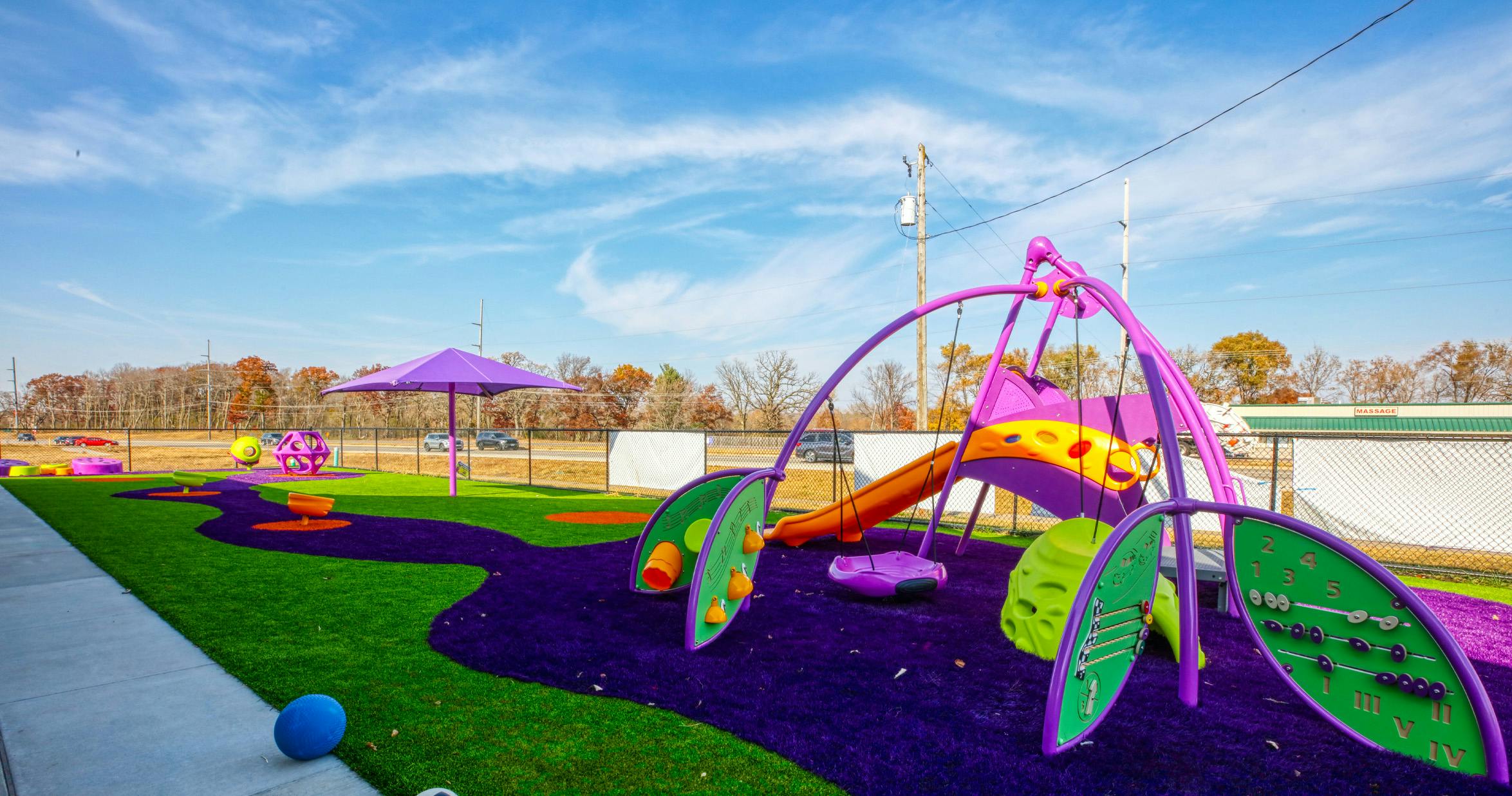Colorful playground with purple and green artificial turf